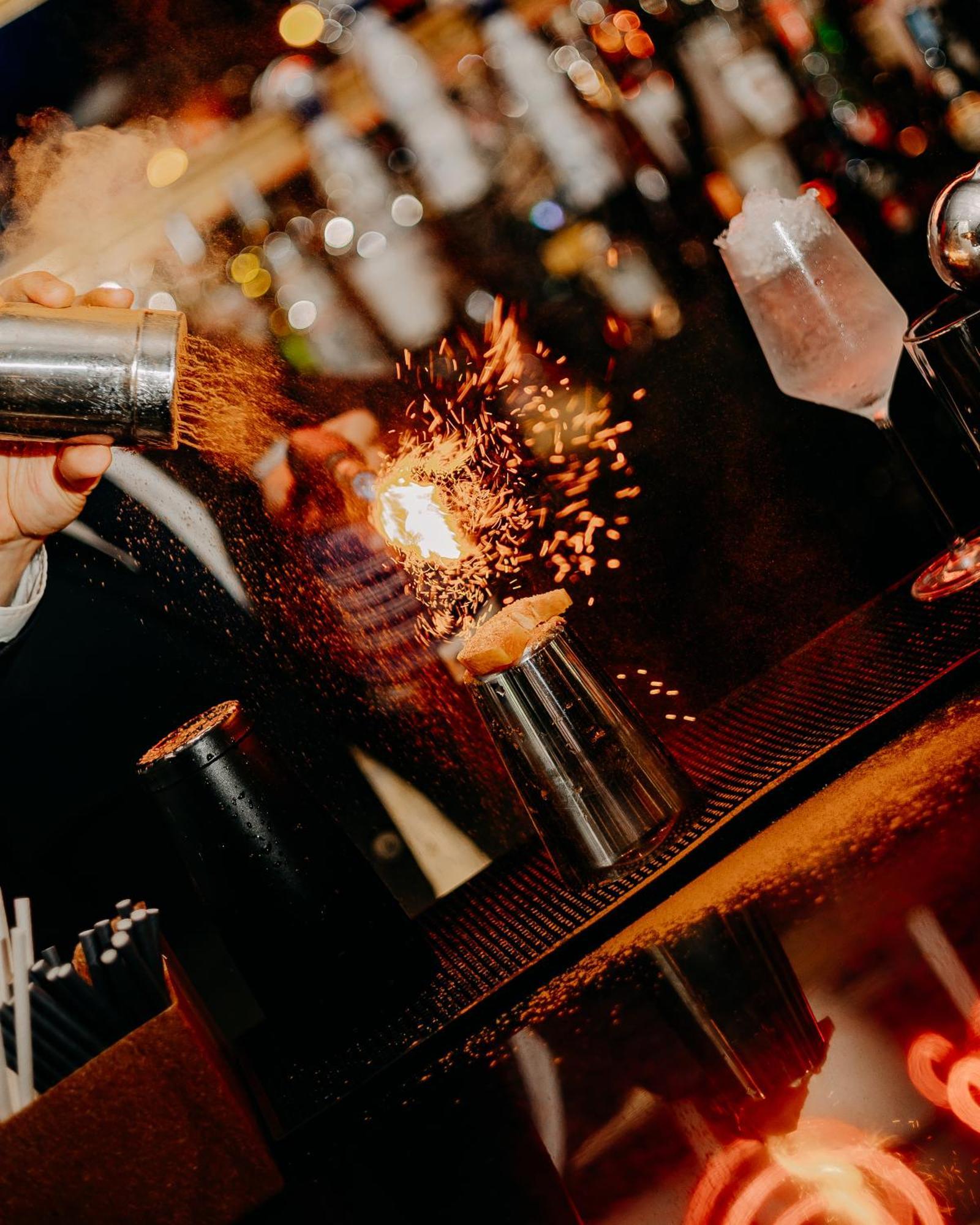 138 Liberdade Hotel Lisbon Luaran gambar A bartender using a cocktail gun to make a flaming shot